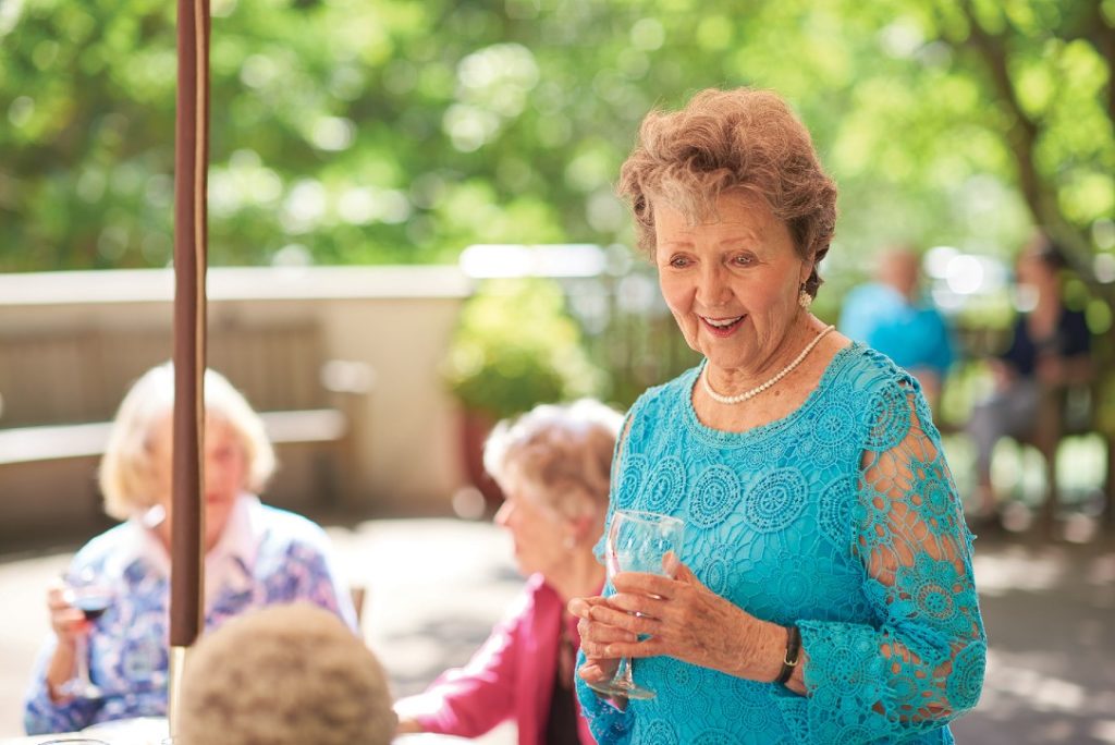 elderly woman talking with friends at a happy hour