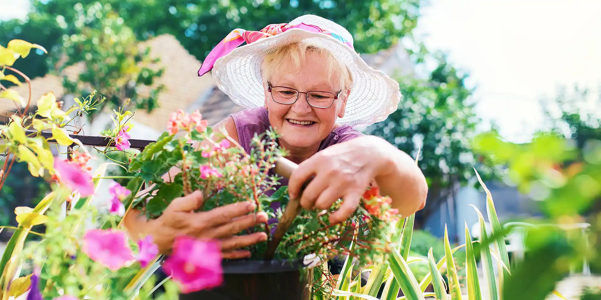 Retired woman with sunhat outside in the garden