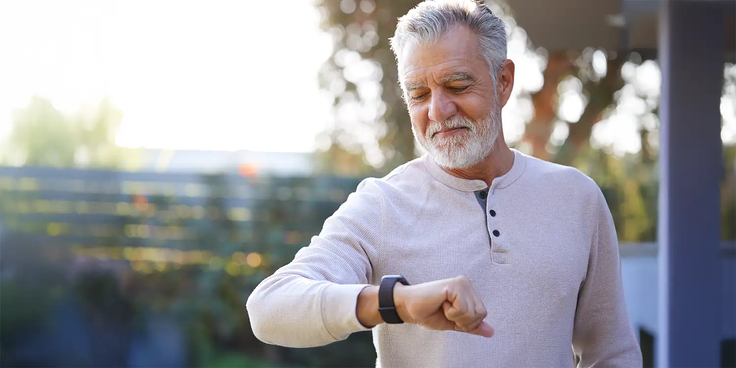 Retired person looking at their smart watch.