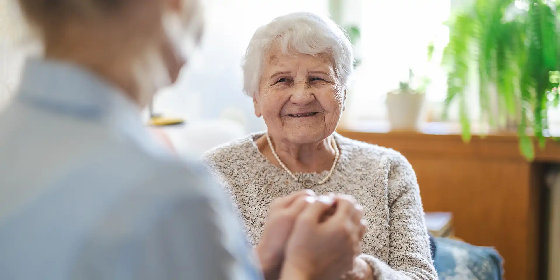 Retired mother and daughter holding hands