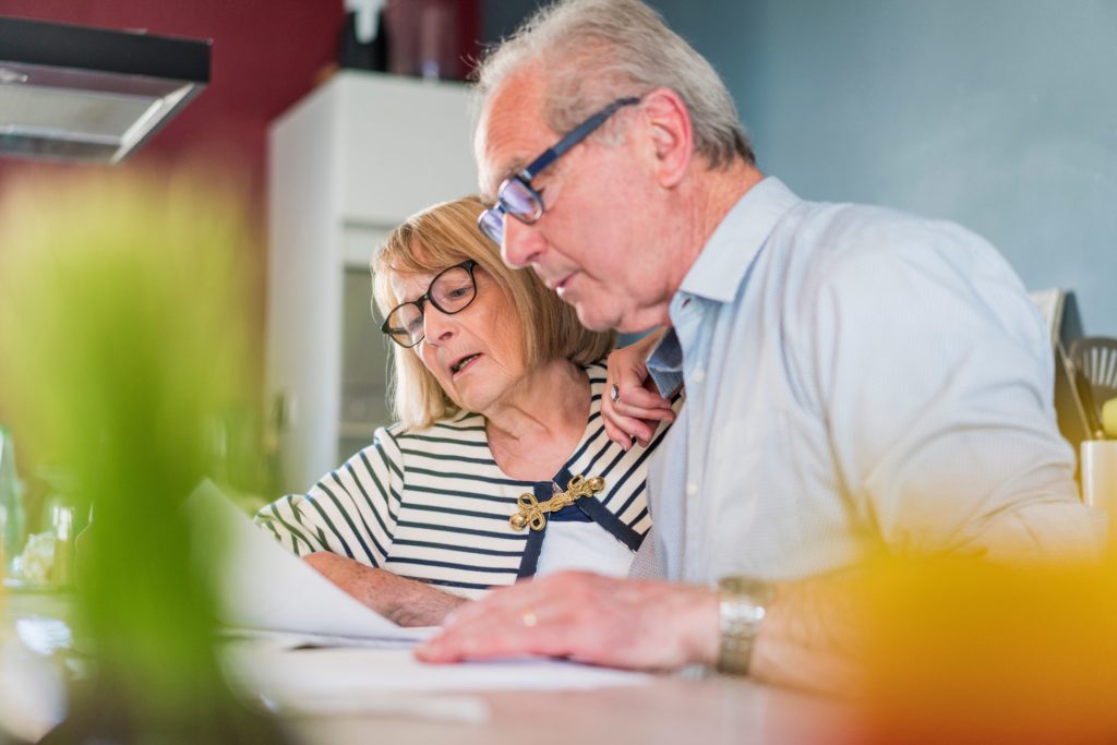 A senior man and woman reviewing finances for retirement living.
