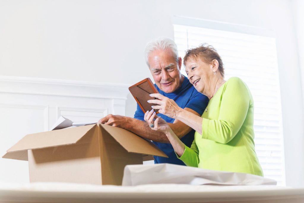 A senior man and woman looking at photos as they downsize.