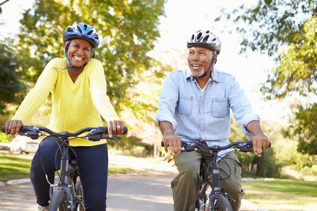 Happy senior couple biking together