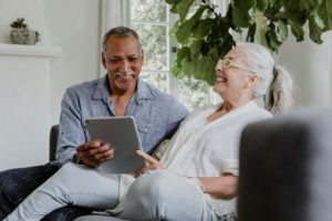 Elderly couple looking at senior living options on a tablet.