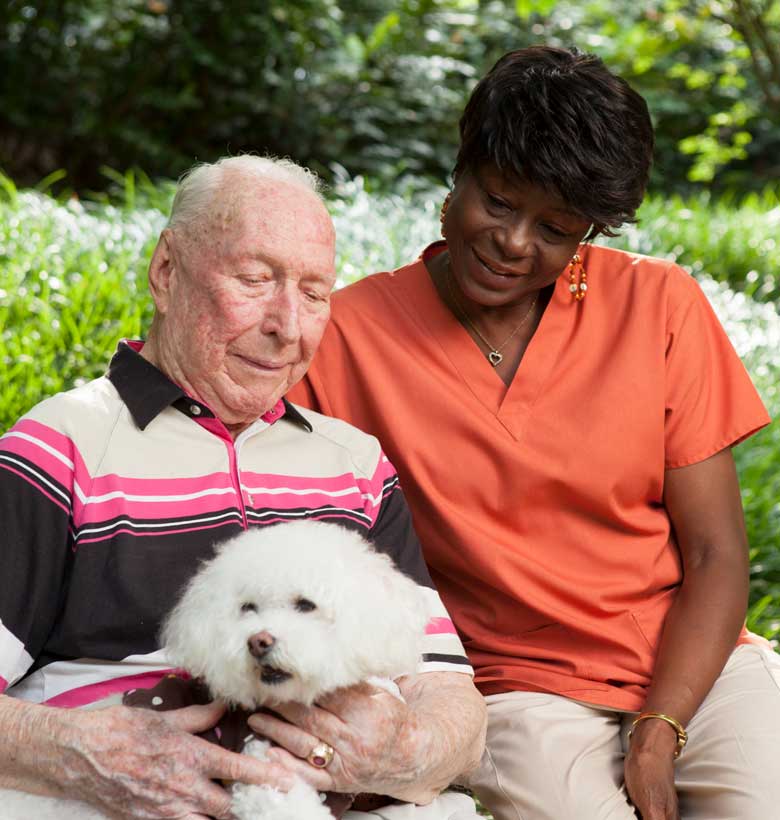Caregiver with Canterbury Court resident holding his dog