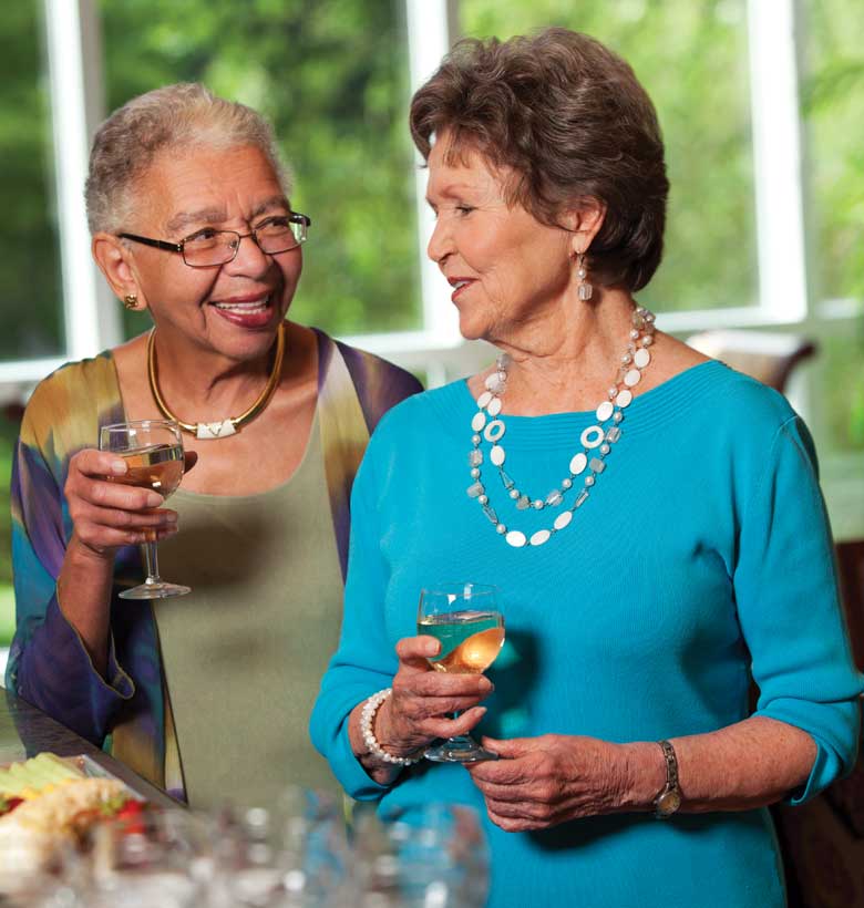 Senior women talking together while enjoying a glass of wine
