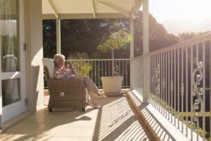 a senior woman basks in the sun on her balcony