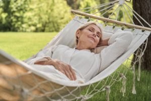 Senior woman laying down on a hammock